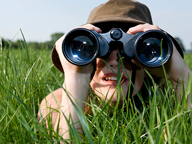  Child in the grass looking through binoculars